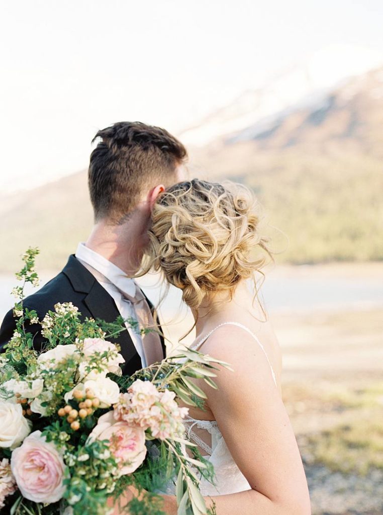 Couple looking at the Alaska mountains during their destination wedding