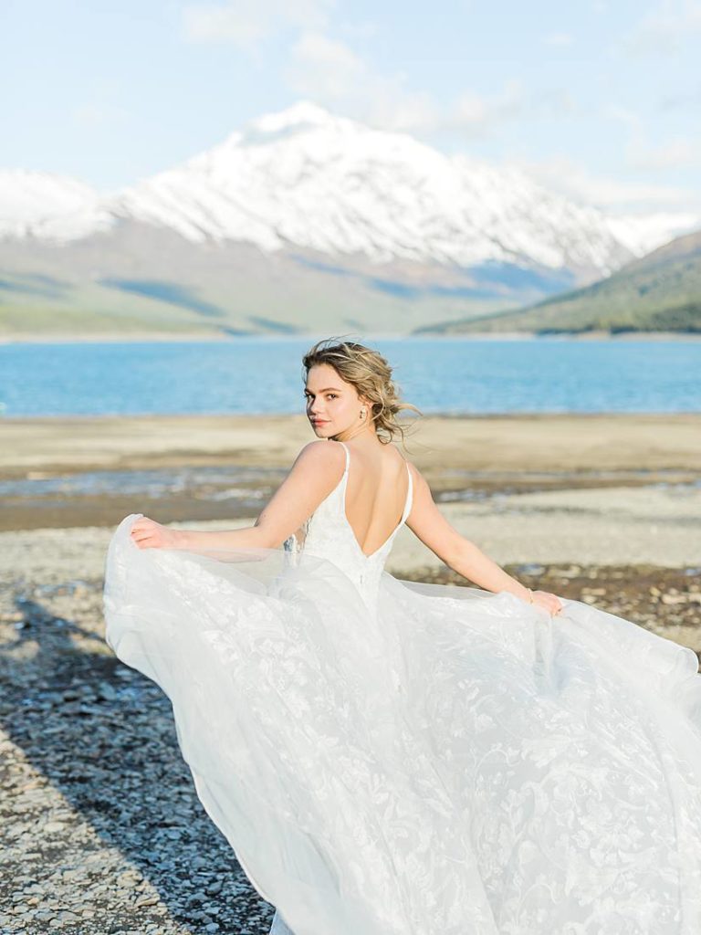 Bridal portrait with her gown flowing in the wind at Eklutna Lake